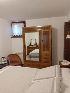 a bedroom with a bed and a dresser and a mirror at Cosy Home in Belluno