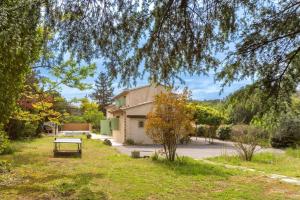 un parc avec un banc devant un bâtiment dans l'établissement La Provence : Piscine, Tennis, Cinéma & Plus, à Roquefort-les-Pins
