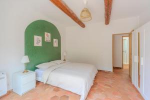 une chambre avec un lit blanc et un mur vert dans l'établissement La Provence : Piscine, Tennis, Cinéma & Plus, à Roquefort-les-Pins 36 autres photos
