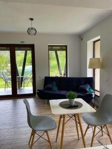 a living room with a couch and a table and chairs at Transylvania Mountain View CDI in Bran