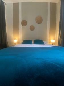 ein Schlafzimmer mit einem Bett mit blauer Bettwäsche und zwei Lampen in der Unterkunft RINCONCITO DEL TURIA ZAPA2 in Valencia