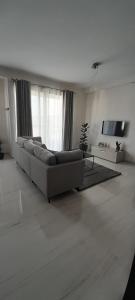 un soggiorno bianco con divano e TV di Coral Reef Apartments a San Pawl il-Baħar