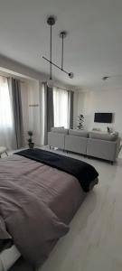 una camera bianca con un grande letto e un divano di Coral Reef Apartments a San Pawl il-Baħar
