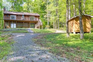 una casa grande en el bosque con entrada en Lakefront Maryland Cabin with Fire Pit, Grill and Deck, en Lusby