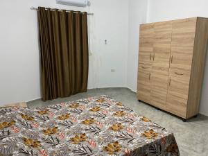 1 dormitorio con cama y tocador de madera en Barbarous, en Ajim