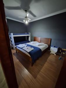 a bedroom with a bed with a blue comforter at Pousada Casa Familia in Nova Iguaçu