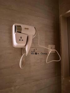 telefono appeso a un muro in una stanza di Rum Bright Moon Camp a Wadi Rum