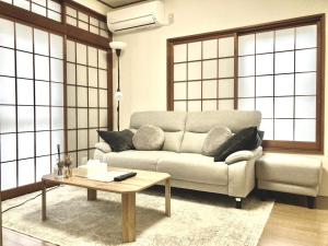 een woonkamer met een bank en een salontafel bij KIBA HOUSE in Tokyo