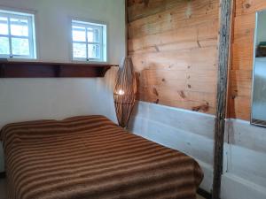 sypialnia z łóżkiem i drewnianą ścianą w obiekcie Casa Verde w mieście Areal