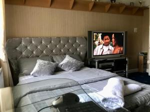 a bedroom with a bed and a tv on a wall at Clayton Home in Manchester