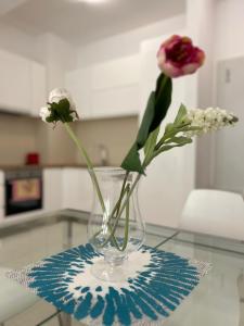 a vase with flowers in it on a table at Pool and spa apartment 1BR in Donji Morinj