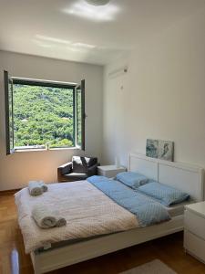 um quarto com uma cama grande e uma janela em Pool and spa apartment 1BR em Donji Morinj