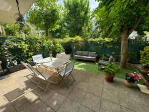 een patio met een tafel en stoelen in een tuin bij Le jardin du stade by UTA HOUSE in Saint-Denis