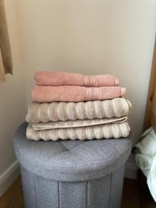 a stack of towels sitting on top of a ottoman at Immaculate 2-Bed Lodge in Hayle in Hayle