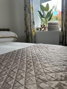 a bedroom with a bed with a quilt on it at Immaculate 2-Bed Lodge in Hayle in Hayle