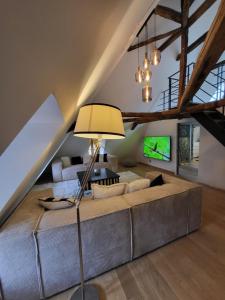 a living room with a couch and a lamp at LA MAISON 1788 in Meymac
