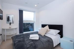 マンチェスターにあるModern MediaCity 2Bed Apartment, Amazing Views, Smart TVsのベッドルーム1室(大型ベッド1台、タオル2枚付)