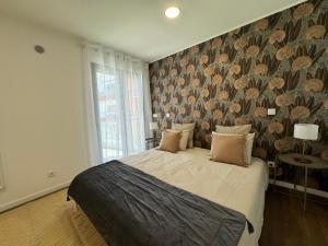 a bedroom with a large bed with a floral wallpaper at Stay In Virtudes I in Funchal