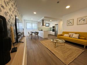 a living room with a yellow couch and a table at Stay In Virtudes I in Funchal