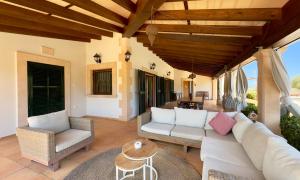a living room with a couch and chairs on a patio at Traumhafte Finca am Es Trenc in Ses Covetes