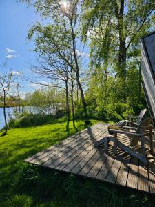 una terraza de madera con banco y mesa de picnic en Tiny house De Ljip en Westergeest