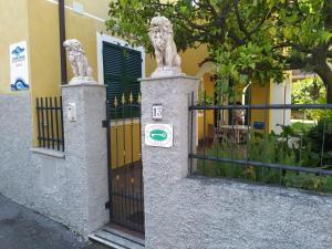 a gate with two lion statues on it next to a building at Andoramare B&B in Marina di Andora