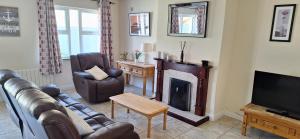 a living room with a couch and a fireplace at Lios na Mara Lahinch in Lahinch