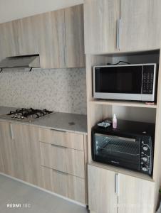 una cocina con microondas y estufa en VILLA TROU AUX BICHES, en Trou aux Biches