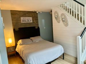 a small bedroom with a bed and a staircase at Condo Loft at Blue Mountain in Blue Mountains