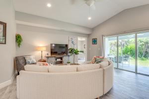 uma sala de estar com dois sofás brancos e uma televisão em Bright Rotonda West Home with Patio, 7 Mi to Beach! em Rotunda-West
