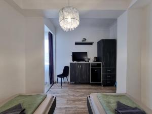 a bedroom with two beds and a chair and a chandelier at DunaCentroom in Dunaújváros