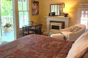 1 dormitorio con 1 cama, chimenea y mesa en Rosemont B&B Cottages, en Little Rock