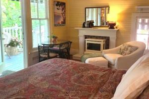 a bedroom with a bed and a fireplace and a table at Rosemont B&B Cottages in Little Rock