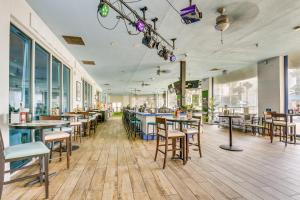 ein Restaurant mit Tischen, Stühlen und Fenstern in der Unterkunft Palms of Destin Poolside Oasis - Walk to Beach! in Destin
