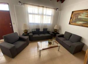 uma sala de estar com dois sofás e uma mesa de centro em casa y bungalows frente al mar em Rosarito