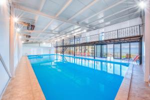 a large indoor swimming pool with blue water at Villaggio Mirzaani Resort in Sighnaghi