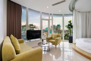 a living room with a bed and a large window at The Rixx Ben Thanh Tower - The One Saigon in Ho Chi Minh City