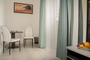 a dining room with two chairs and a table with a bowl of fruit at DunaCentroom in Dunaújváros