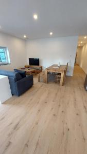 a living room with a blue couch and a wooden table at Ferienwohnung Zur Hofreite in Mörlenbach