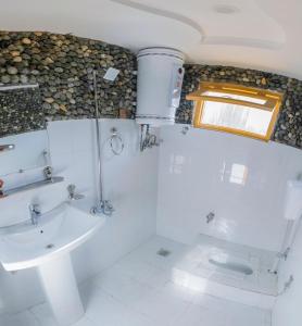 La salle de bains est pourvue d'un lavabo, de toilettes et d'une fenêtre. dans l'établissement Royal Brangsa Guest House, à Skardu