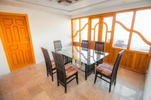 Royal Brangsa Guest House في سكردو: غرفة طعام مع طاولة وكراسي زجاجية