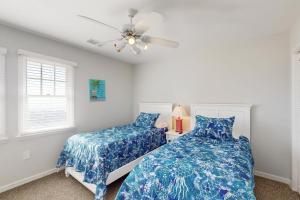 a bedroom with two beds and a ceiling fan at Conch #4A-CAC in Buxton +26 photos