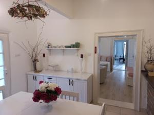 a kitchen with a table with a vase of flowers on it at Tornácos Vendégház in Hajdúnánás