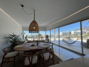 a dining room with a table and chairs and a large window at Beautiful modern apartement with Jacuzzi, 1 km from the beach in Torremuelle
