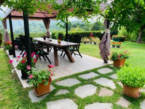 stół i krzesła pod altaną z kwiatami w obiekcie B&B Codivilla w mieście Sasso Marconi +9 zdjęć