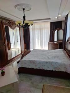 um quarto com uma cama e um lustre em NINO em Kobuleti