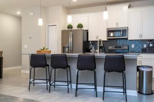 a kitchen with a counter with four stools at Finding Nemo! Amazing Home & Free Waterpark 4963 in Kissimmee