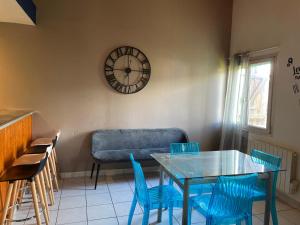 a dining room with a table and chairs and a clock at Appartement au porte de Geneve in Saint-Genis-Pouilly