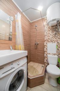 a bathroom with a washing machine and a toilet at Затишна студія, 5 хвилин від Південного вокзалу in Kharkiv +7 photos