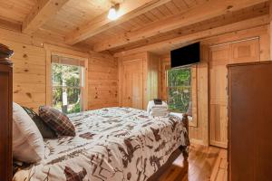 una camera con un letto in una baita di tronchi di Lake Lure Oasis in the Woods w/ Hot Tub & More! a Lake Lure